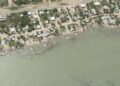 Vista aérea de Carboneras: la carretera, la hilera de casas, las lanchas varadas en la orilla y, en el agua, las estacas colocadas en triángulo (charangas) para capturar camarón.
