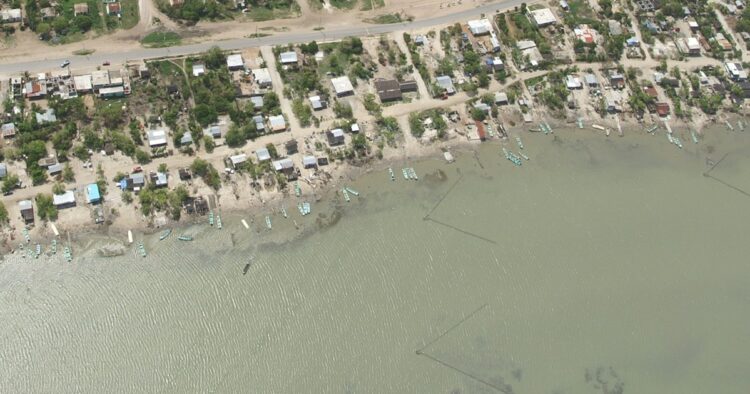 Vista aérea de Carboneras: la carretera, la hilera de casas, las lanchas varadas en la orilla y, en el agua, las estacas colocadas en triángulo (charangas) para capturar camarón.